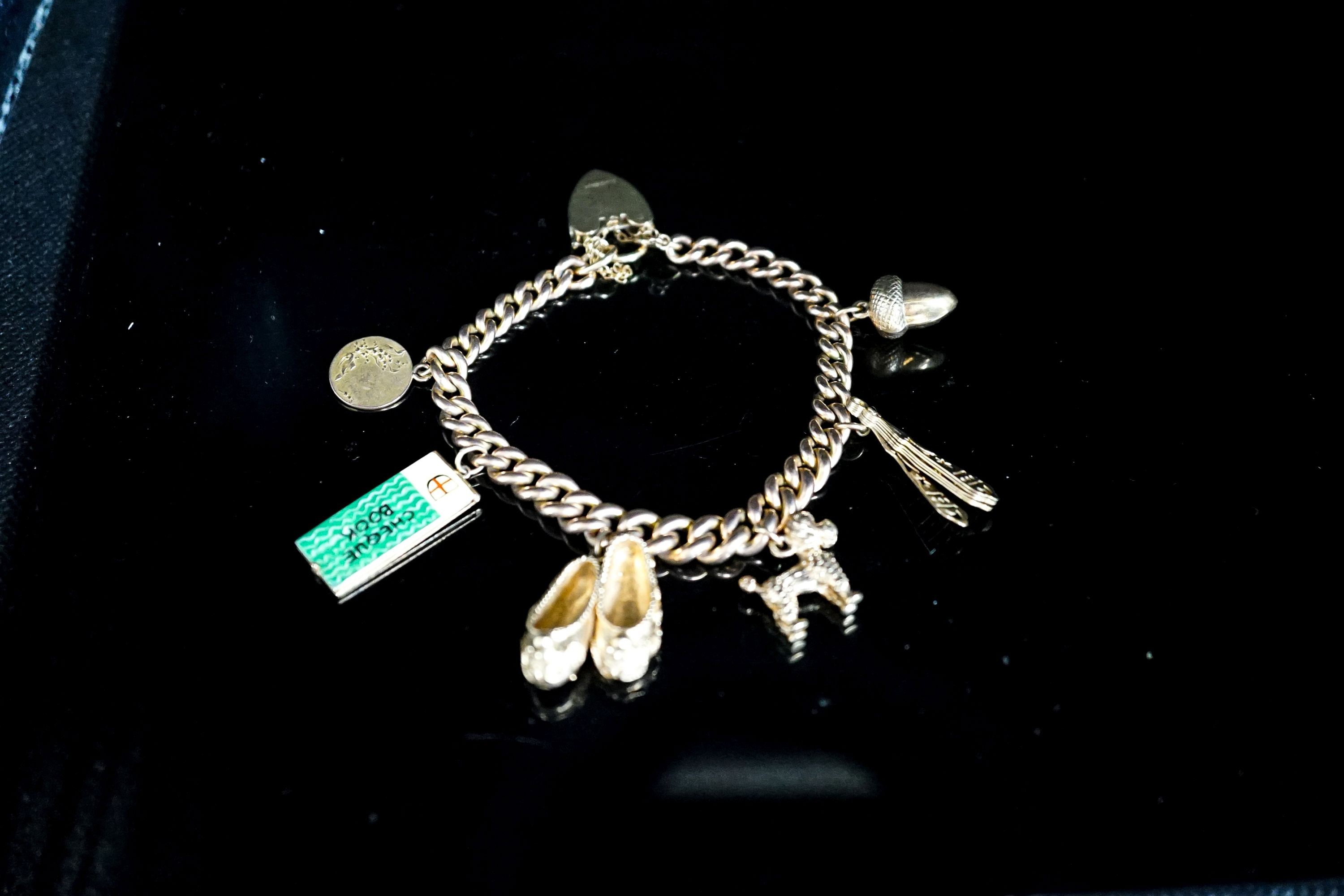 A 9ct curb link charm bracelet, hung with seven assorted charms, gross weight 38.8 grams.